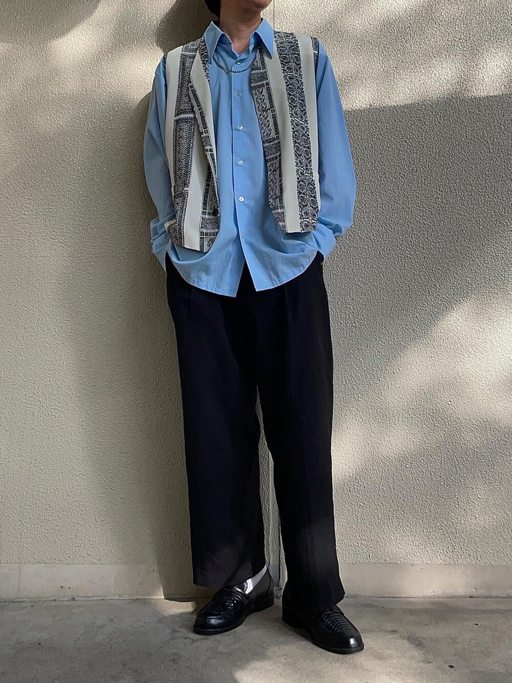 ブラック系のスラックス、シルバー系のネックレスを着用したメンズの春コーディネートの2枚目の写真