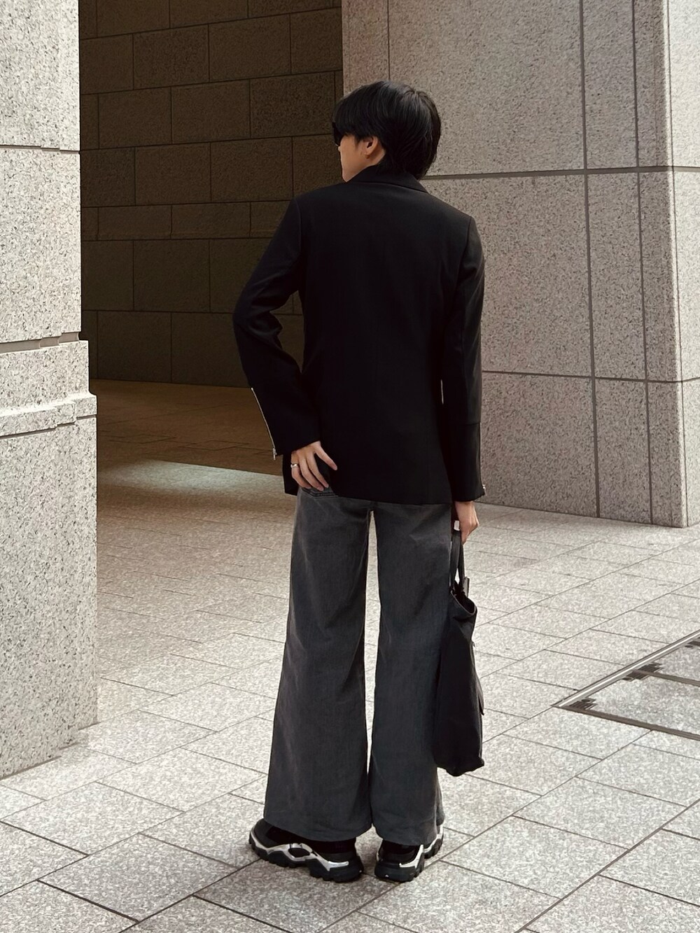 ブラック系のスニーカー、グレー系のデニムパンツ、ブラック系のトートバッグを着用したメンズの秋コーディネートの3枚目の写真