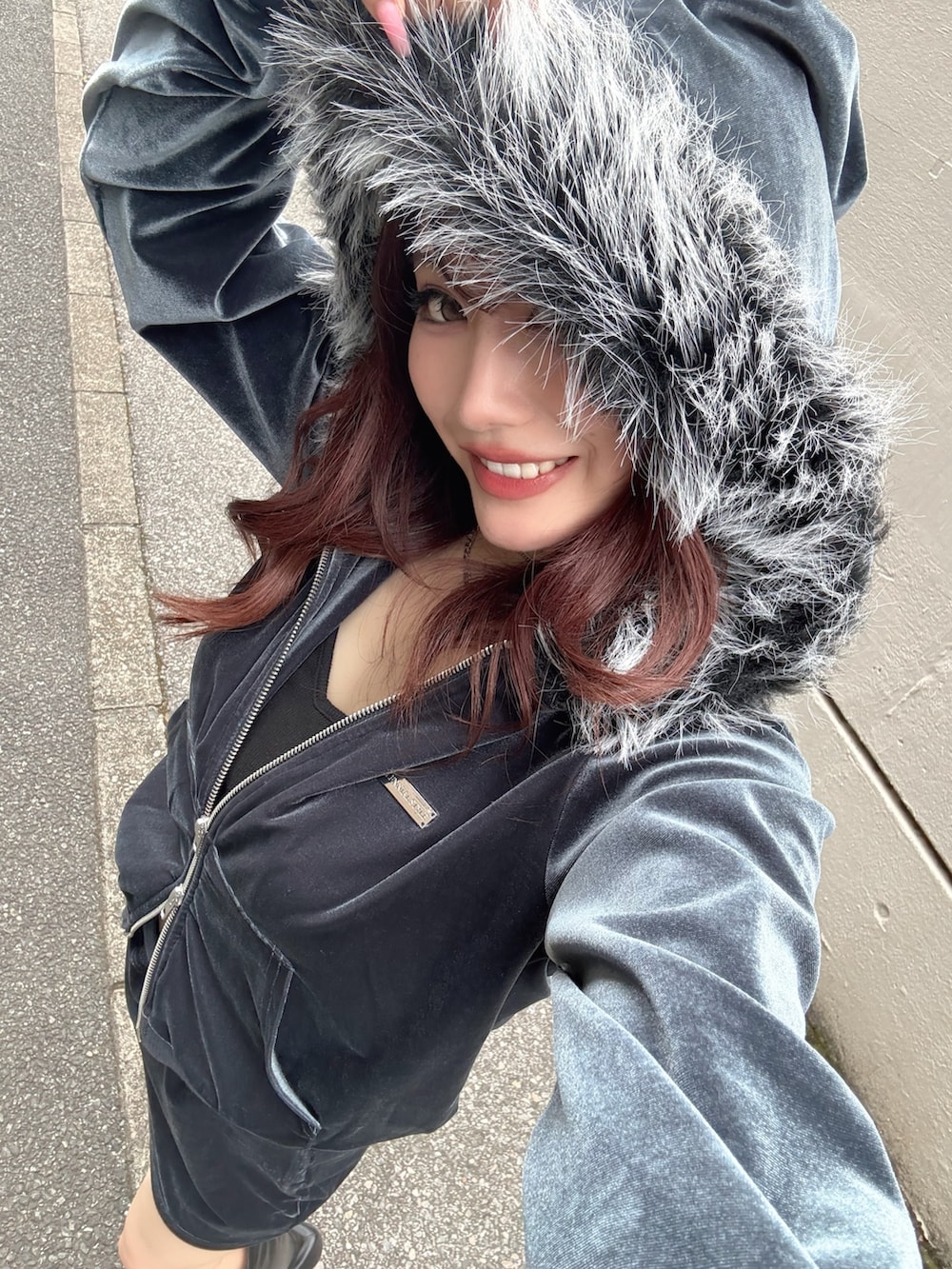 ブルー系のスカート、ブルー系のパーカー、ブラック系のブーツを着用したレディースの秋コーディネートの5枚目の写真