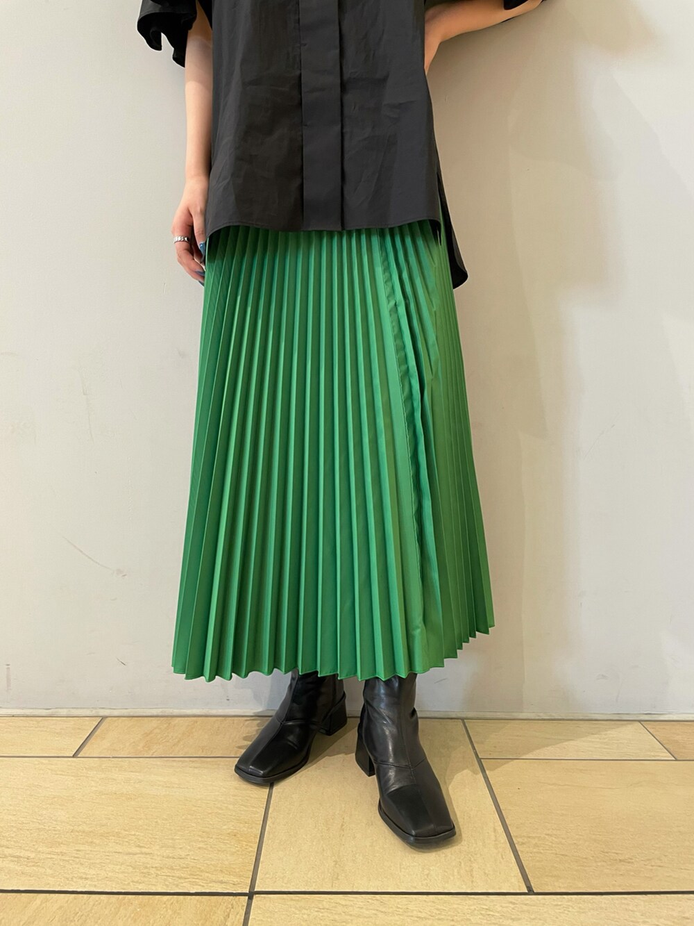 ブラック系のシャツ/ブラウス、グリーン系のスカート、ブラック系のブーツを着用したレディースの夏コーディネートの3枚目の写真