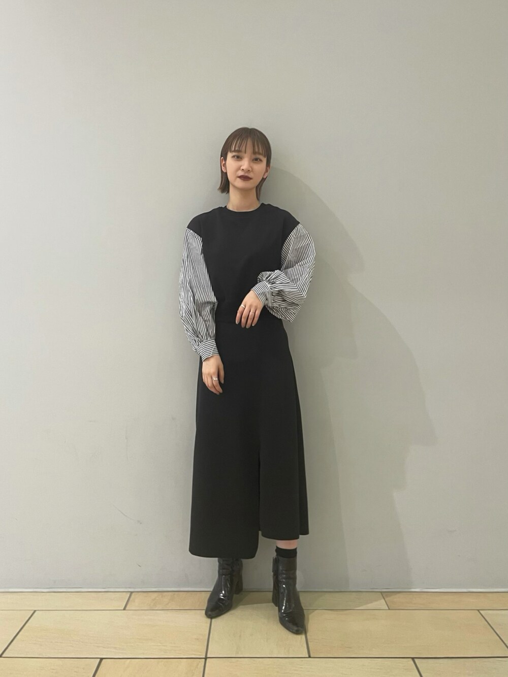 ブラック系のTシャツ/カットソー、ブラック系のスカートを着用したレディースの冬コーディネートの2枚目の写真