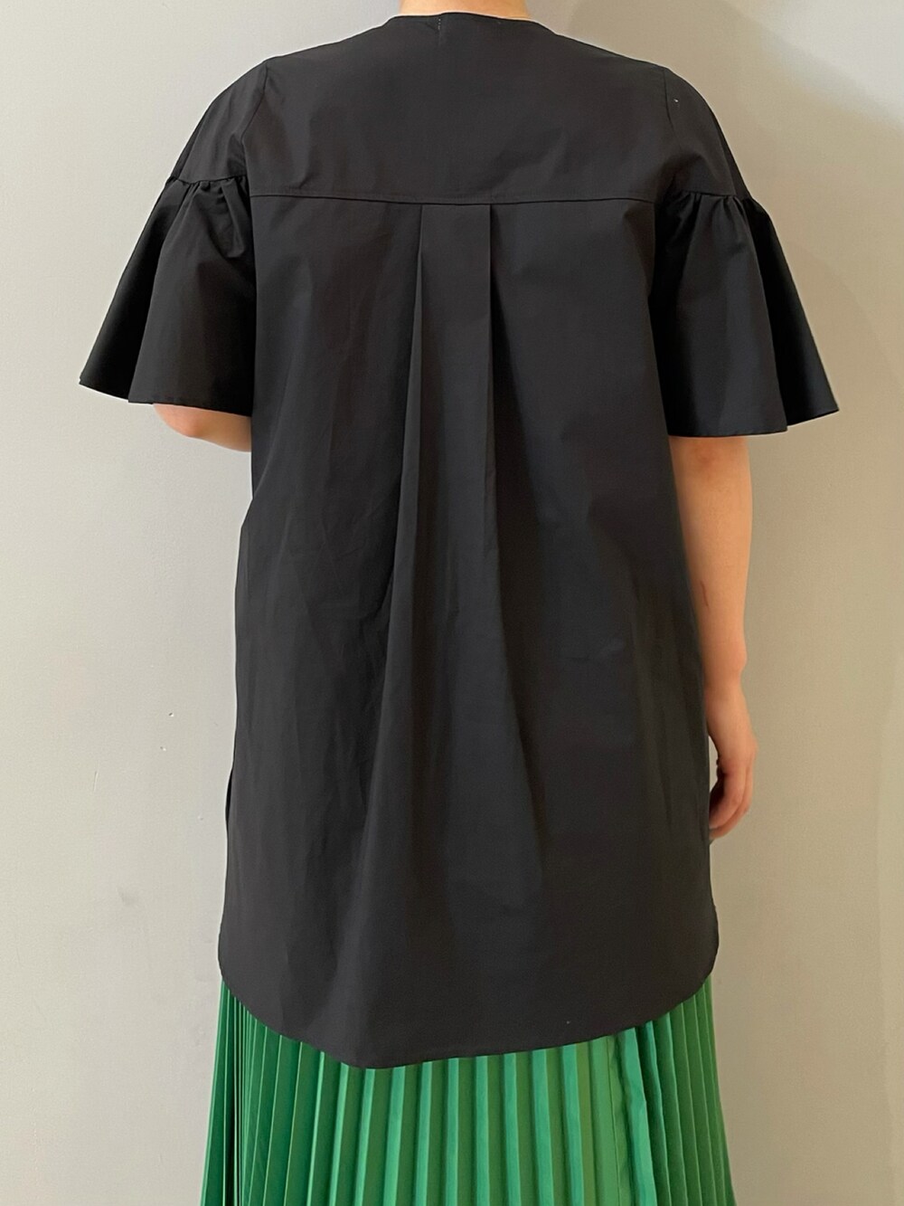 ブラック系のシャツ/ブラウス、グリーン系のスカート、ブラック系のブーツを着用したレディースの夏コーディネートの2枚目の写真