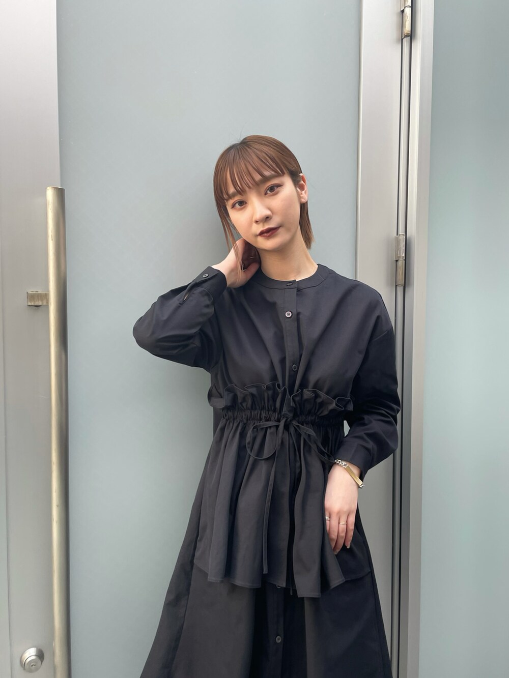 ブラック系のブーツ、ブラック系のワンピース、ブラック系のスラックスを着用したレディースの春コーディネートの4枚目の写真