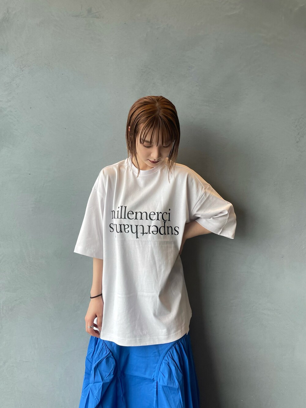 ブルー系のスカート、ホワイト系のTシャツ/カットソーを着用したレディースの春コーディネートの3枚目の写真