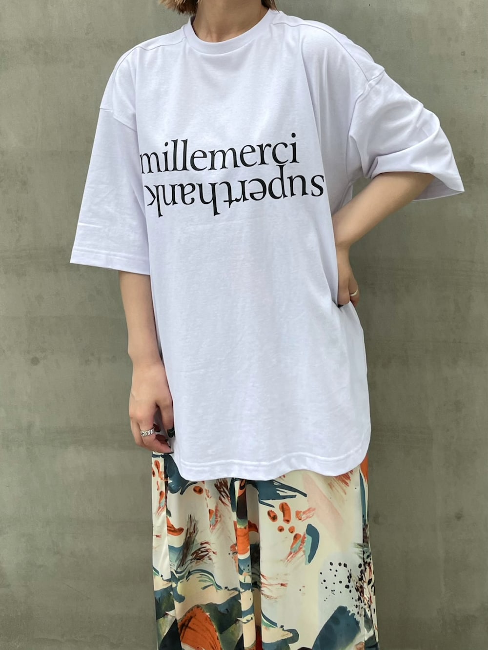 ブラック系のTシャツ/カットソー、オレンジ系のワンピースを着用したレディースの夏コーディネートの3枚目の写真