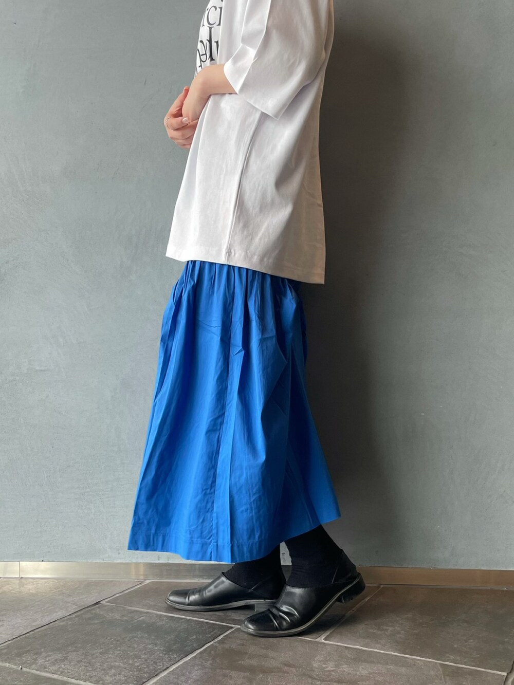 ブルー系のスカート、ホワイト系のTシャツ/カットソーを着用したレディースの春コーディネートの4枚目の写真