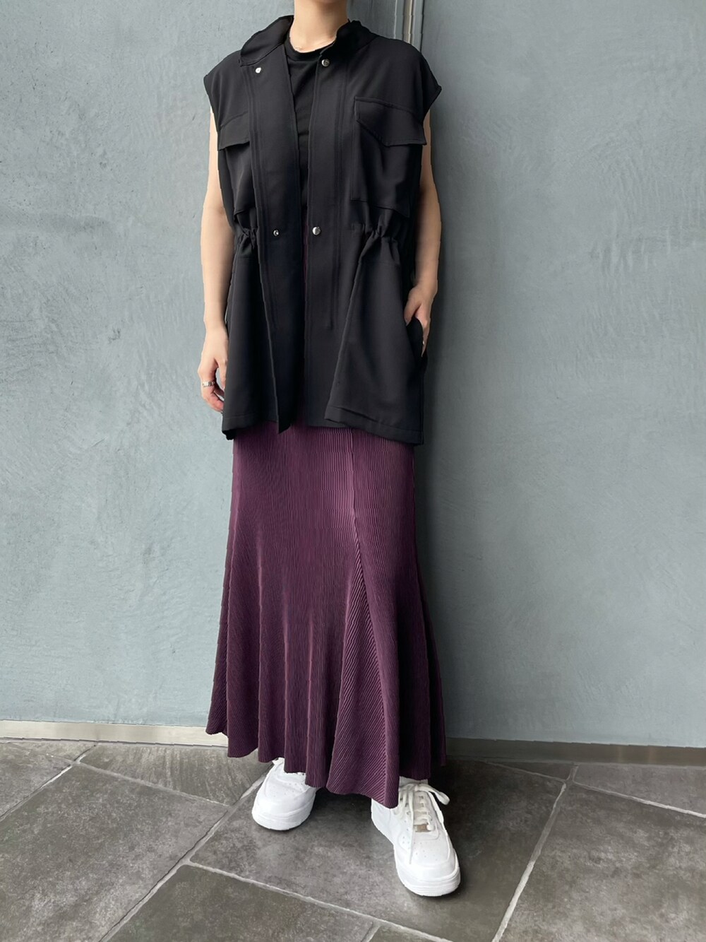 ブラック系のベスト、パープル系のスカートを着用したレディースの夏コーディネートの5枚目の写真