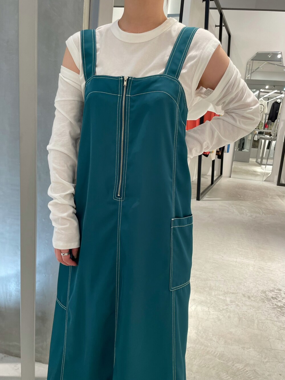 グリーン系のワンピース、ホワイト系のTシャツ/カットソーを着用したレディースの夏コーディネートの2枚目の写真