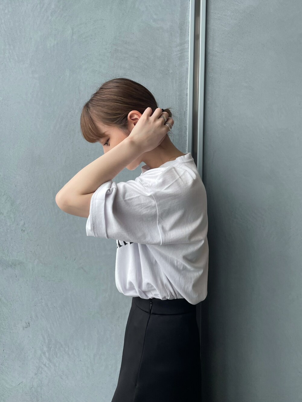 ホワイト系のTシャツ/カットソー、ブラック系のスカートを着用したレディースの夏コーディネートの3枚目の写真