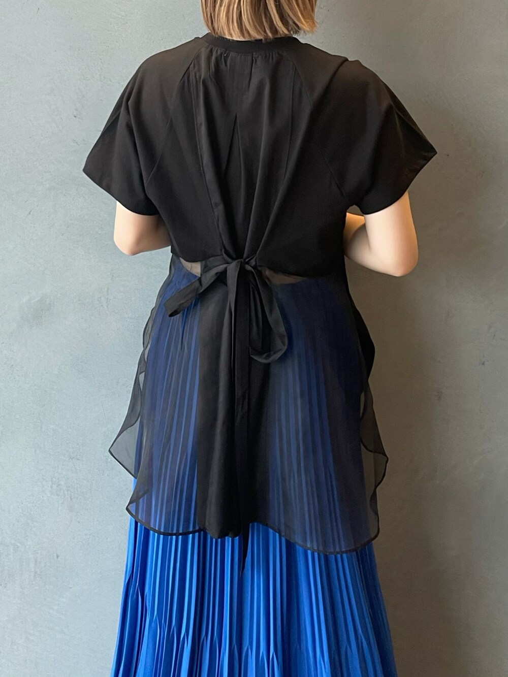 ブルー系のスカート、ブラック系のTシャツ/カットソーを着用したレディースの夏コーディネートの3枚目の写真