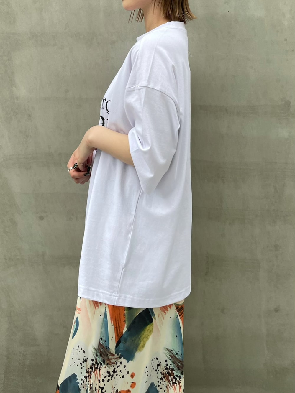 ブラック系のTシャツ/カットソー、オレンジ系のワンピースを着用したレディースの夏コーディネートの2枚目の写真