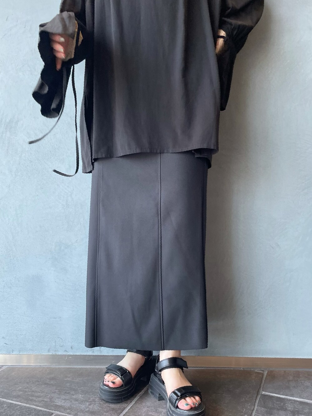 ブラック系のシャツ/ブラウス、ブラック系のスカート、ベージュ系のTシャツ/カットソーを着用したレディースの夏コーディネートの5枚目の写真