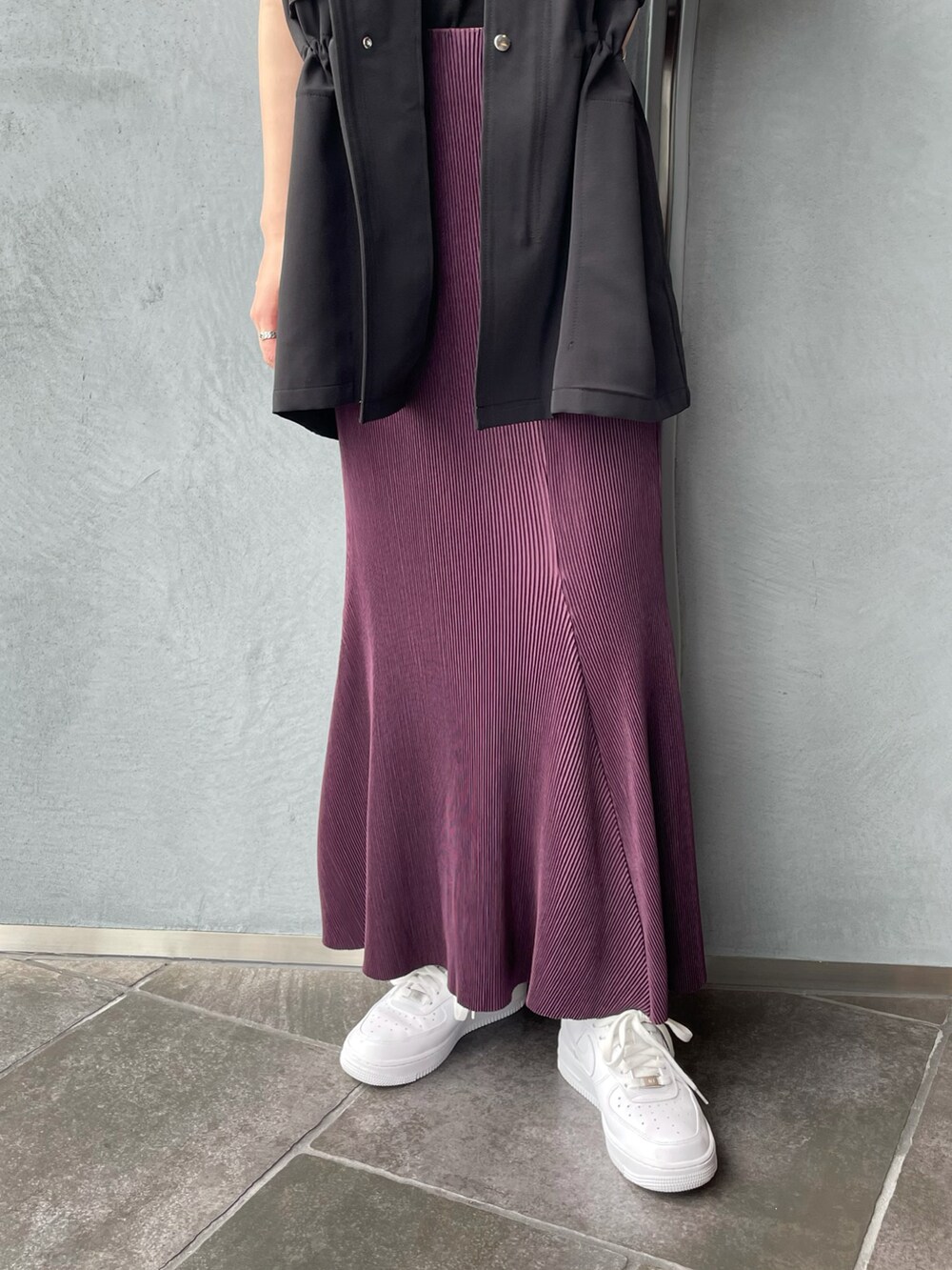 ブラック系のベスト、パープル系のスカートを着用したレディースの夏コーディネートの4枚目の写真