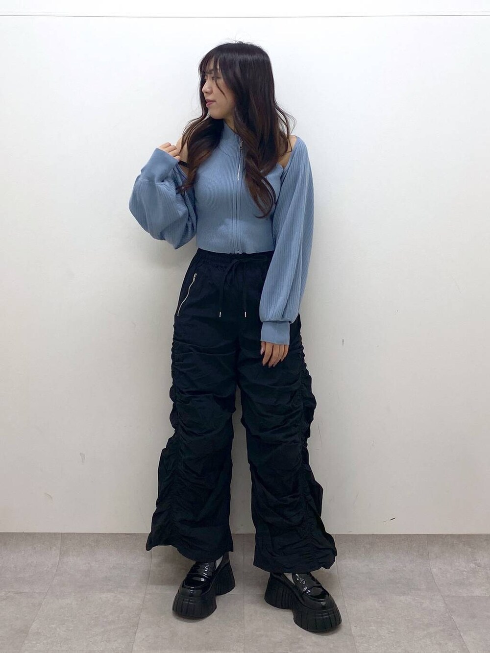 ブラック系のその他パンツ、ブラック系のローファー、ブルー系のニット/セーターを着用したレディースの冬コーディネートの6枚目の写真