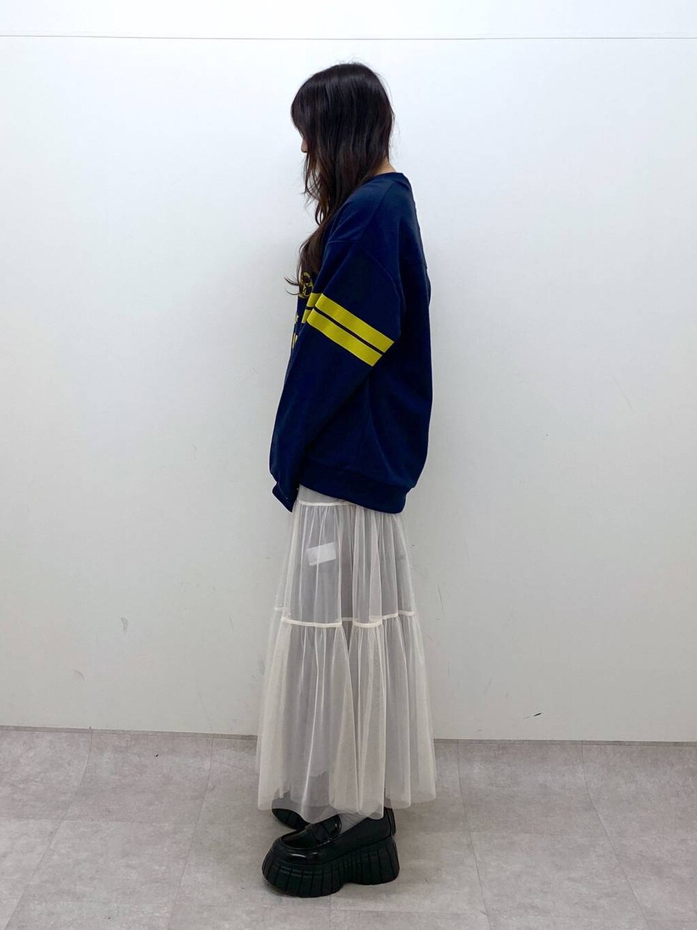 ホワイト系のスカート、ブルー系のTシャツ/カットソー、ブラック系のローファーを着用したレディースの冬コーディネートの3枚目の写真