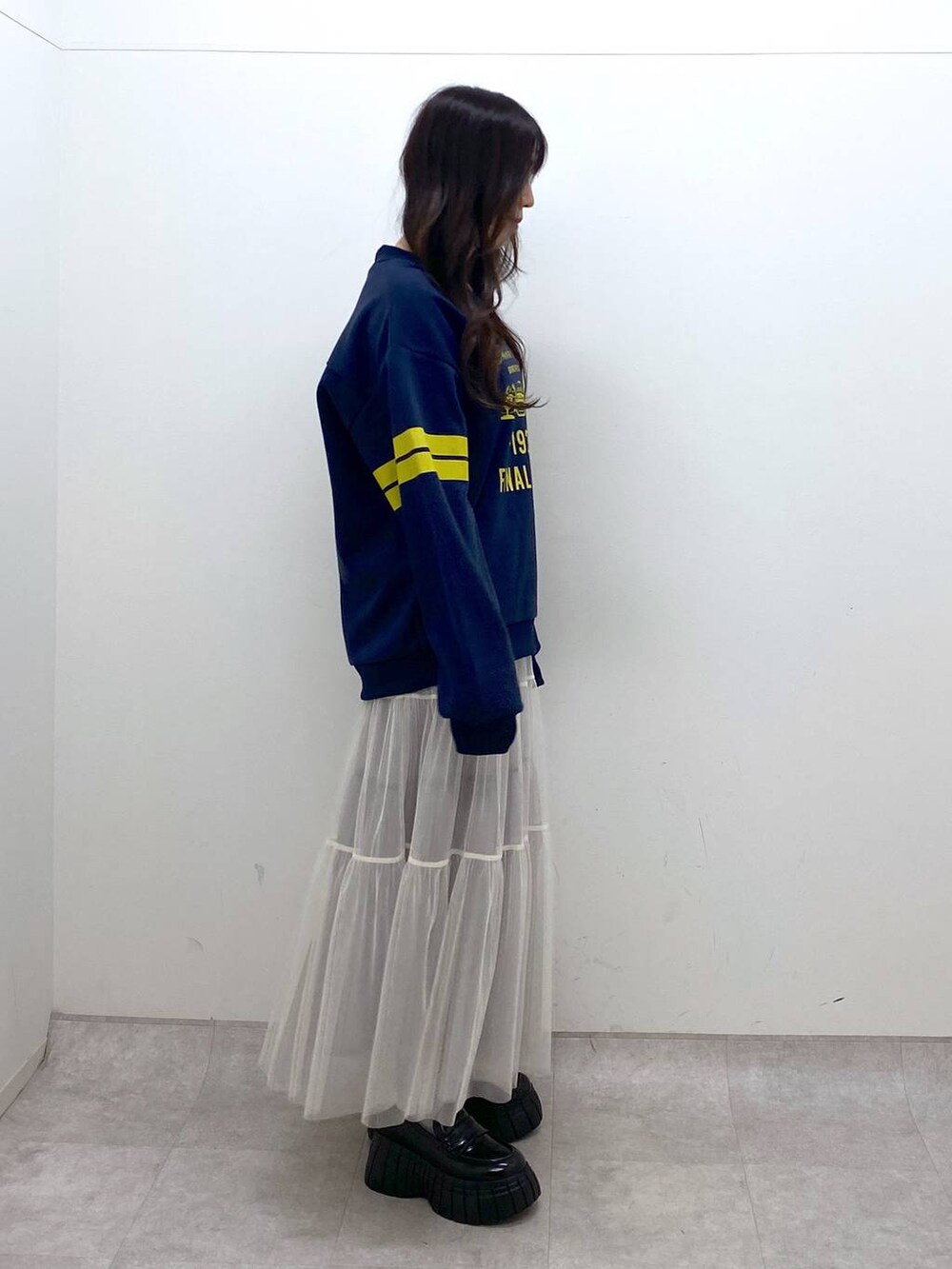 ホワイト系のスカート、ブルー系のTシャツ/カットソー、ブラック系のローファーを着用したレディースの冬コーディネートの5枚目の写真