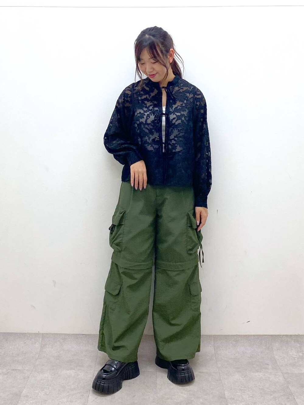 ブラック系のシャツ/ブラウス、グリーン系のカーゴパンツ、ホワイト系のキャミソールを着用したレディースの春コーディネートの2枚目の写真