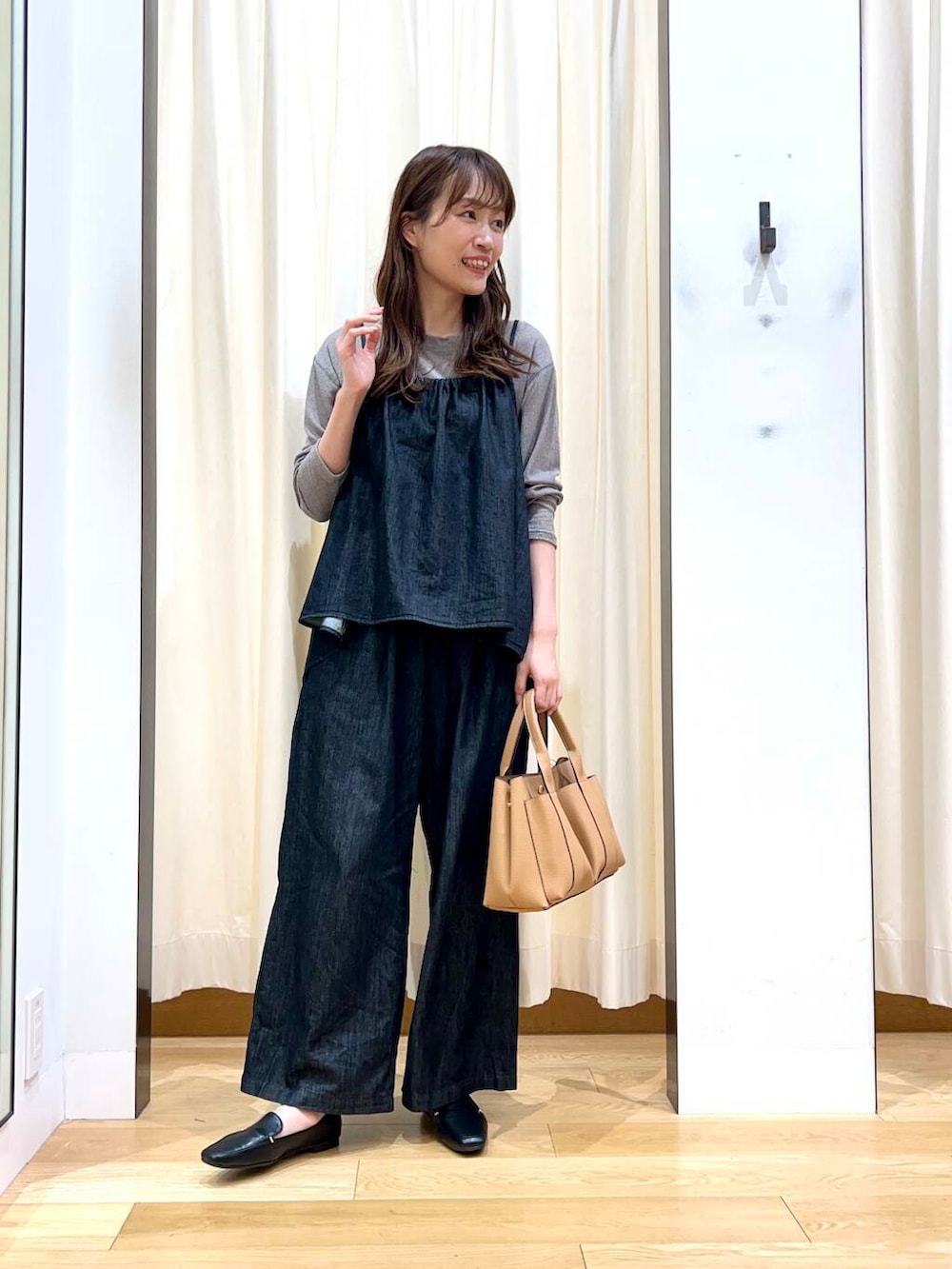 ブラック系のローファー、ベージュ系のトートバッグ、ブラック系のサロペット/オーバーオールを着用したレディースの秋コーディネートの7枚目の写真