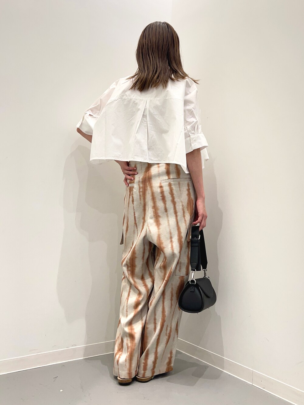 ブラック系のショルダーバッグ、シルバー系のサンダル、ブラウン系のカーゴパンツを着用したレディースの春コーディネートの3枚目の写真