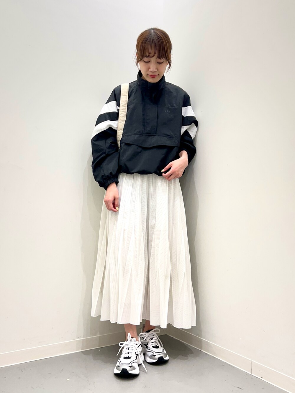 ホワイト系のスニーカー、ホワイト系のスカート、ブラック系のトップスを着用したレディースの春コーディネートの5枚目の写真