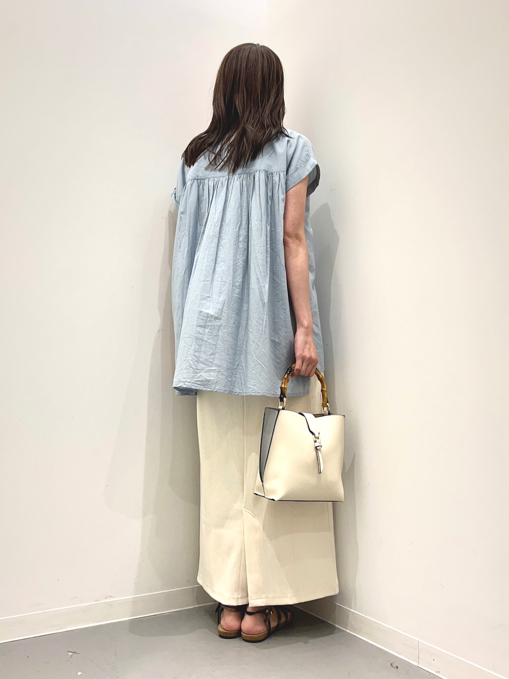 ブルー系のシャツ/ブラウス、ホワイト系のハンドバッグ、ブラウン系のサンダルを着用したレディースの夏コーディネートの3枚目の写真
