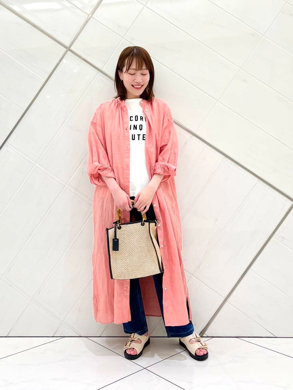 ブルー系のデニムパンツ、ピンク系のワンピース、ホワイト系のTシャツ/カットソーを着用したレディースの春コーディネートの6枚目の写真