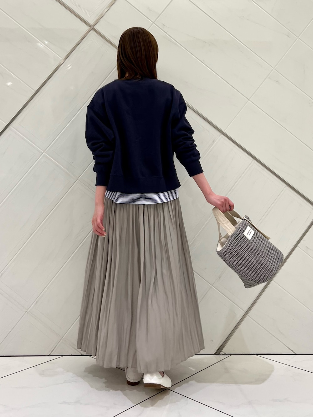 ブルー系のカーディガン/ボレロ、ホワイト系のTシャツ/カットソー、ベージュ系のスカートを着用したレディースの春コーディネートの3枚目の写真