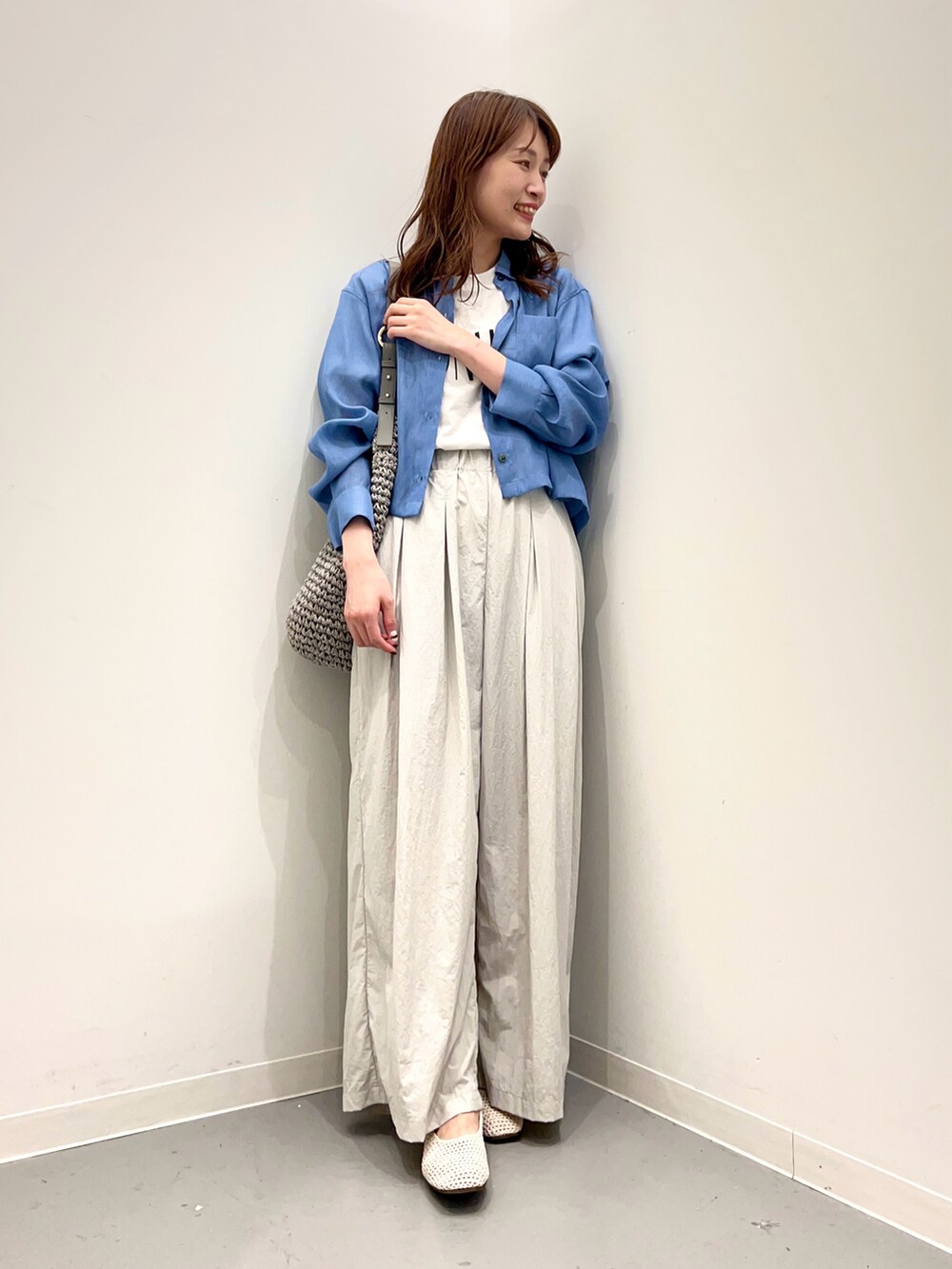 グレー系のトートバッグ、ホワイト系のその他シューズ、グレー系のその他パンツを着用したレディースの春コーディネートの4枚目の写真