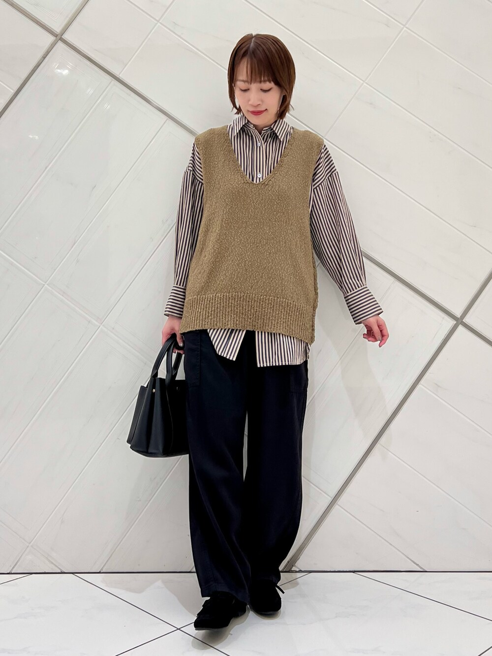 グリーン系のベスト、グレー系のシャツ/ブラウス、ブラック系のその他パンツを着用したレディースの秋コーディネートの5枚目の写真