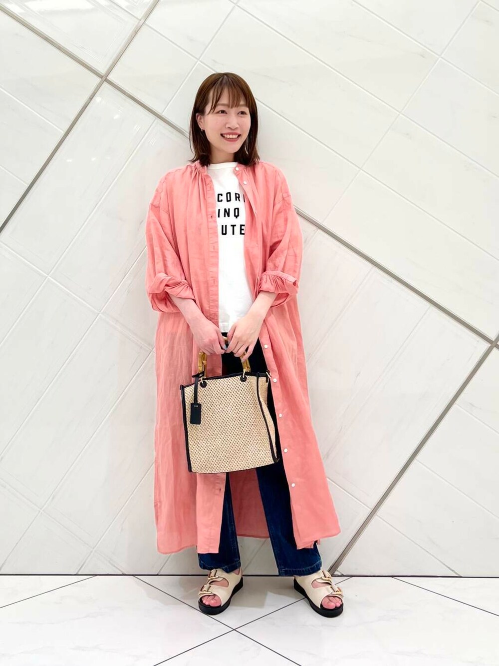 ブルー系のデニムパンツ、ピンク系のワンピース、ホワイト系のTシャツ/カットソーを着用したレディースの春コーディネートの4枚目の写真