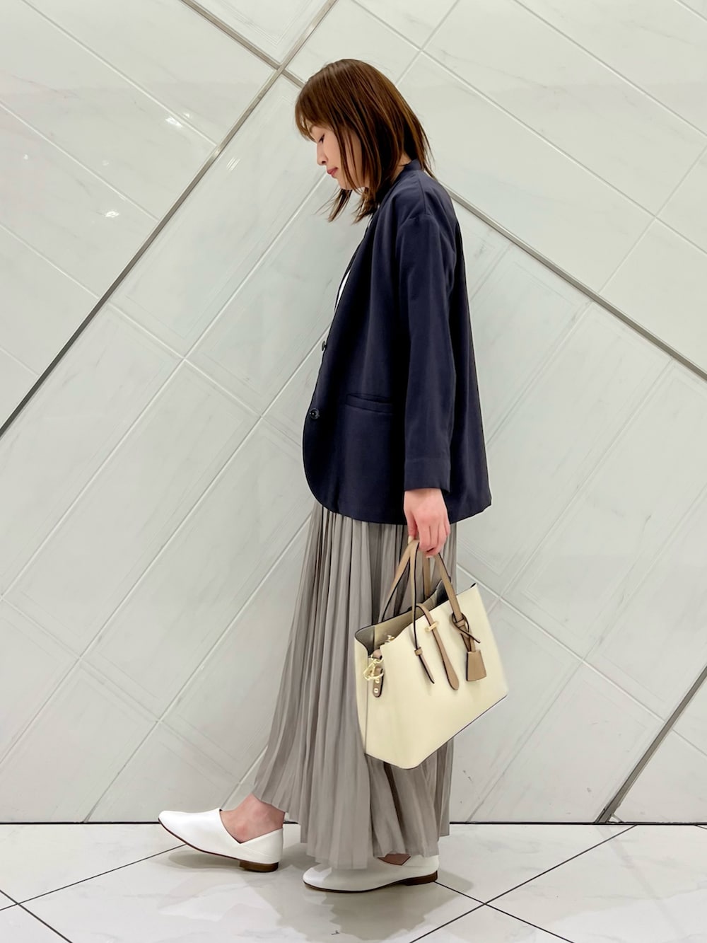 ブルー系のTシャツ/カットソー、グレー系のその他アウター、ベージュ系のスカートを着用したレディースの春コーディネートの2枚目の写真