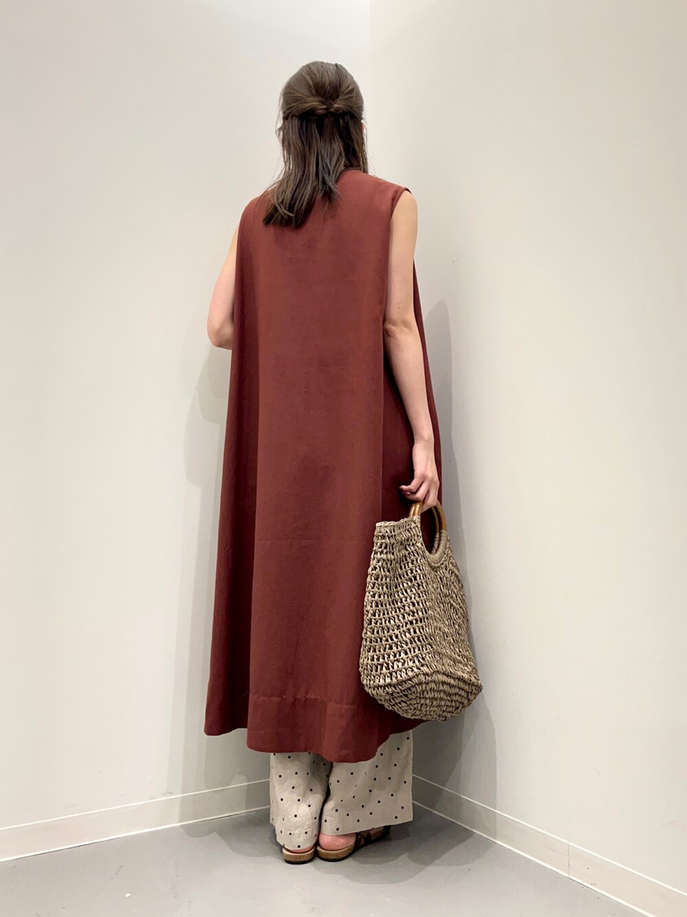 グレー系のトートバッグ、ブラウン系のサンダル、ベージュ系のその他パンツを着用したレディースの夏コーディネートの3枚目の写真