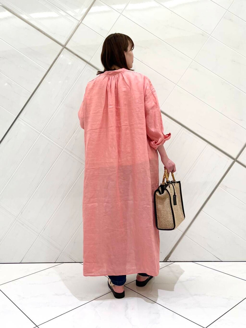ブルー系のデニムパンツ、ピンク系のワンピース、ホワイト系のTシャツ/カットソーを着用したレディースの春コーディネートの3枚目の写真