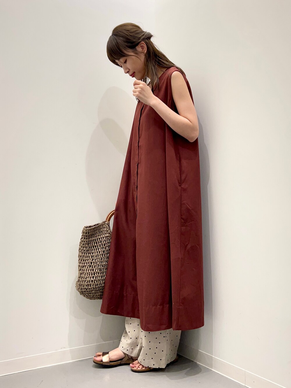 グレー系のトートバッグ、ブラウン系のサンダル、ベージュ系のその他パンツを着用したレディースの夏コーディネートの4枚目の写真