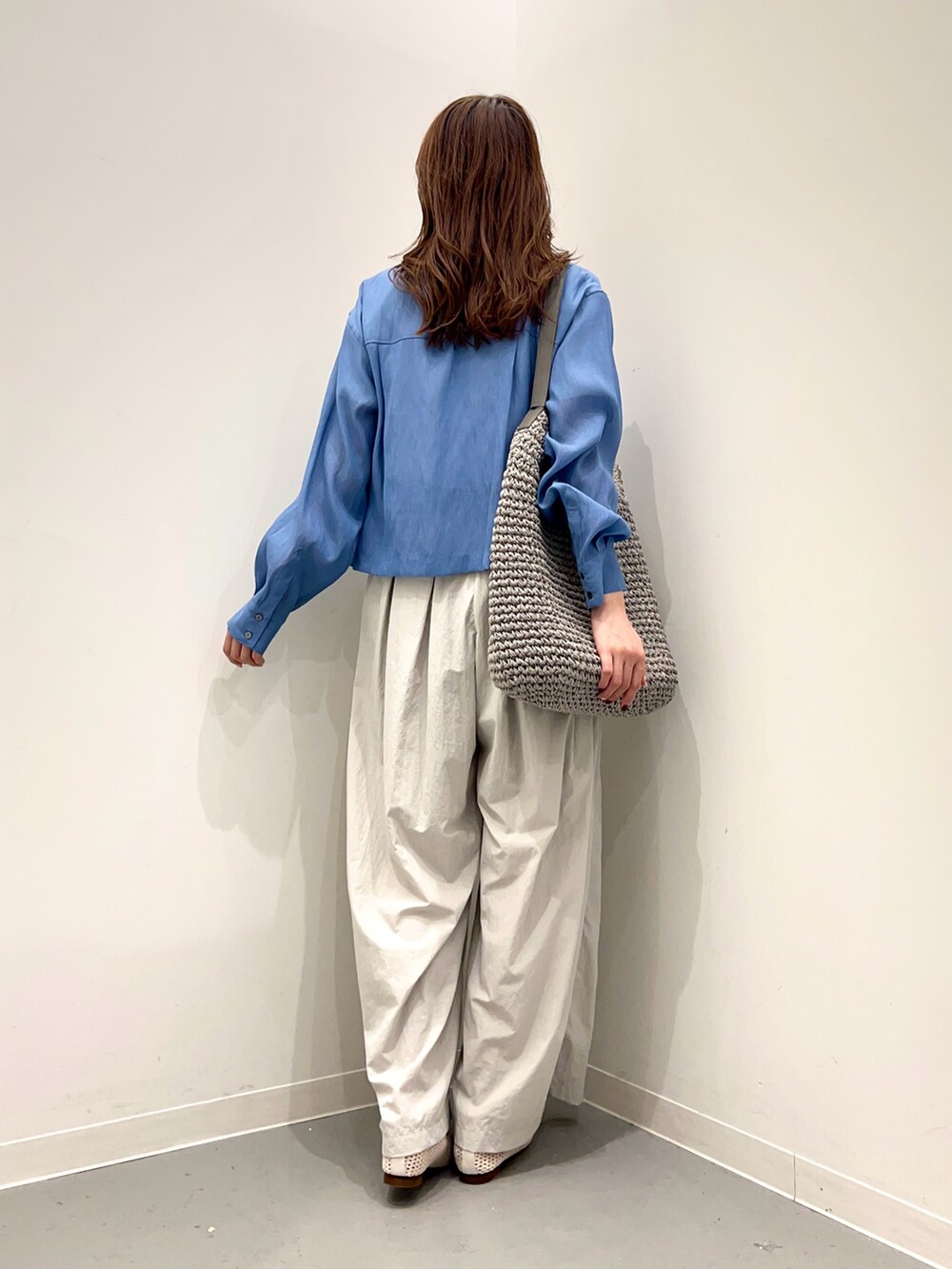 グレー系のトートバッグ、ホワイト系のその他シューズ、グレー系のその他パンツを着用したレディースの春コーディネートの3枚目の写真