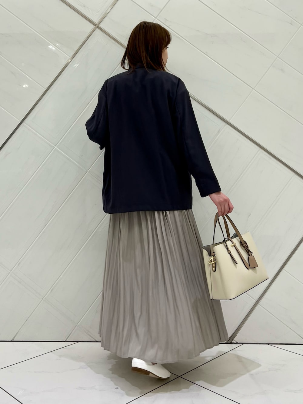 ブルー系のTシャツ/カットソー、グレー系のその他アウター、ベージュ系のスカートを着用したレディースの春コーディネートの3枚目の写真