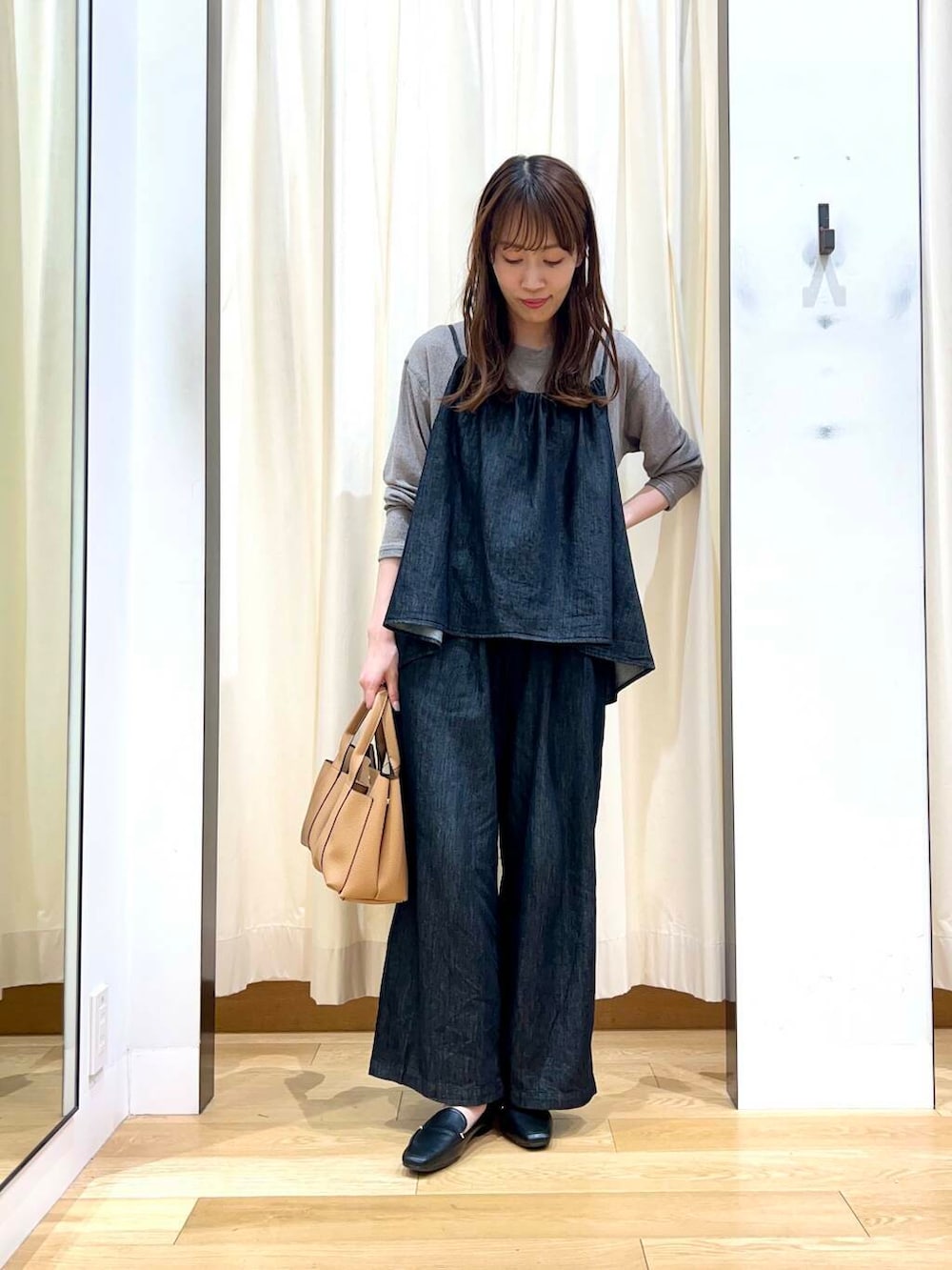 ブラック系のローファー、ベージュ系のトートバッグ、ブラック系のサロペット/オーバーオールを着用したレディースの秋コーディネートの6枚目の写真