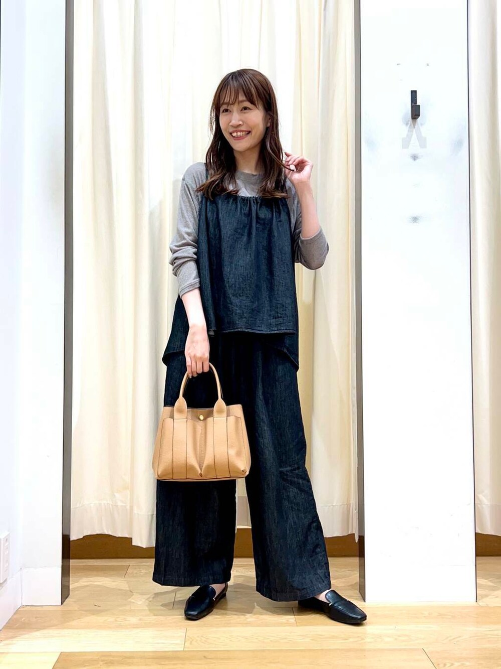 ブラック系のローファー、ベージュ系のトートバッグ、ブラック系のサロペット/オーバーオールを着用したレディースの秋コーディネートの4枚目の写真