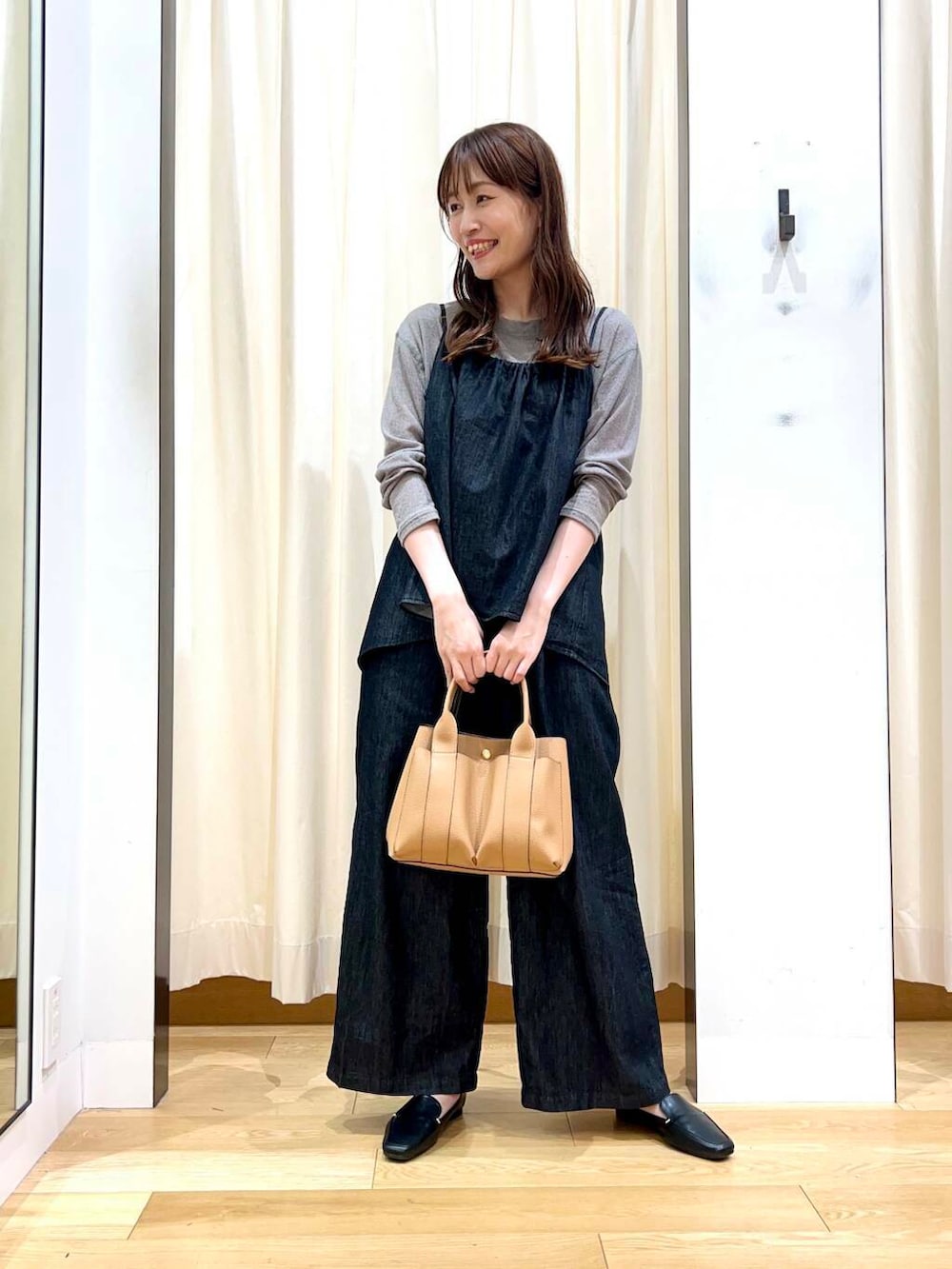 ブラック系のローファー、ベージュ系のトートバッグ、ブラック系のサロペット/オーバーオールを着用したレディースの秋コーディネートの5枚目の写真