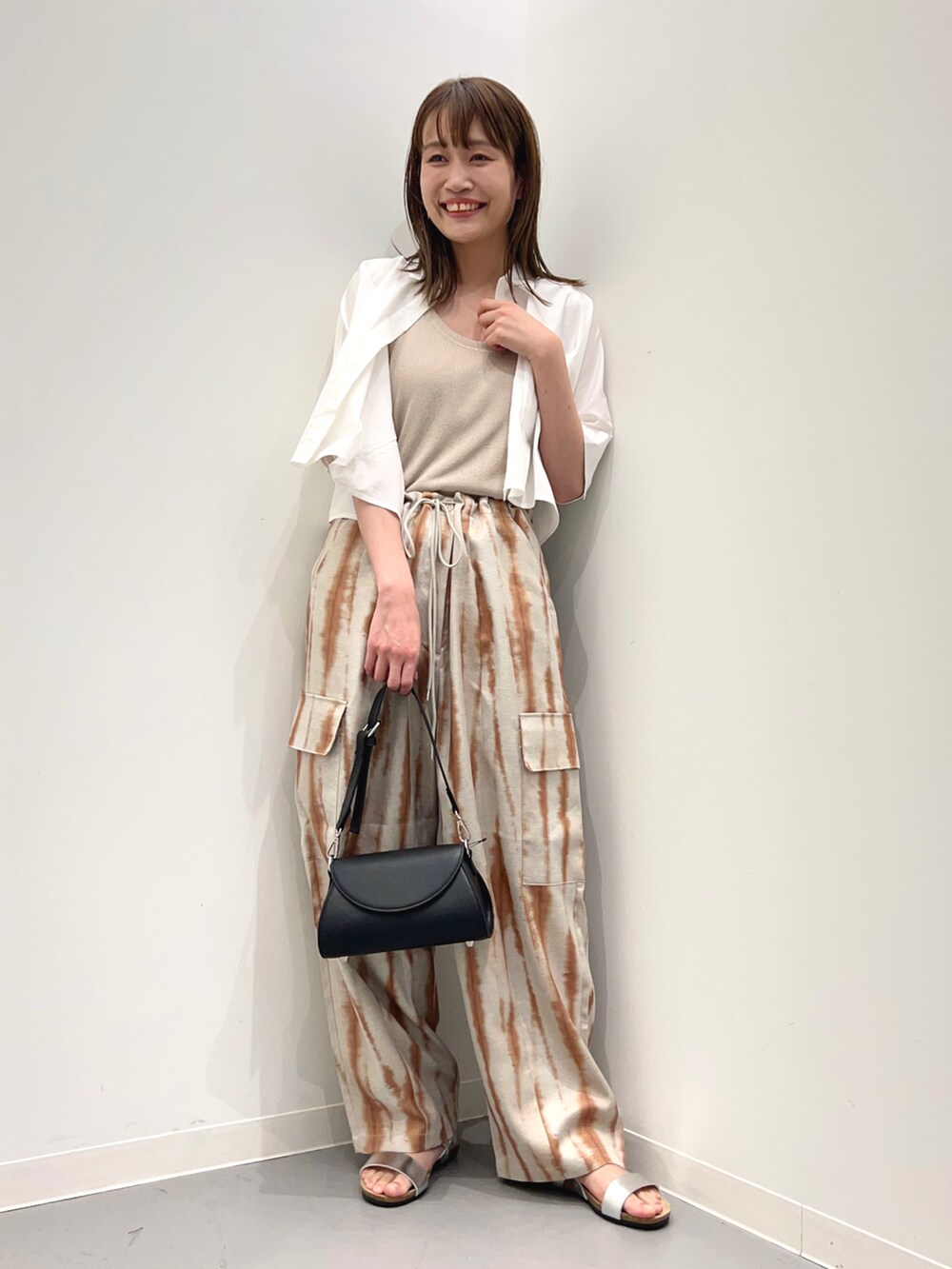 ブラック系のショルダーバッグ、シルバー系のサンダル、ブラウン系のカーゴパンツを着用したレディースの春コーディネートの4枚目の写真