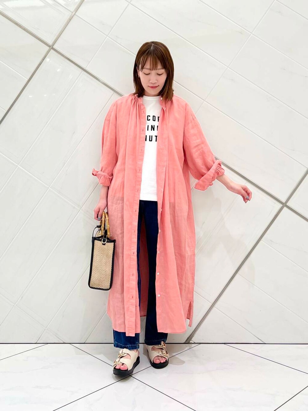 ブルー系のデニムパンツ、ピンク系のワンピース、ホワイト系のTシャツ/カットソーを着用したレディースの春コーディネートの5枚目の写真