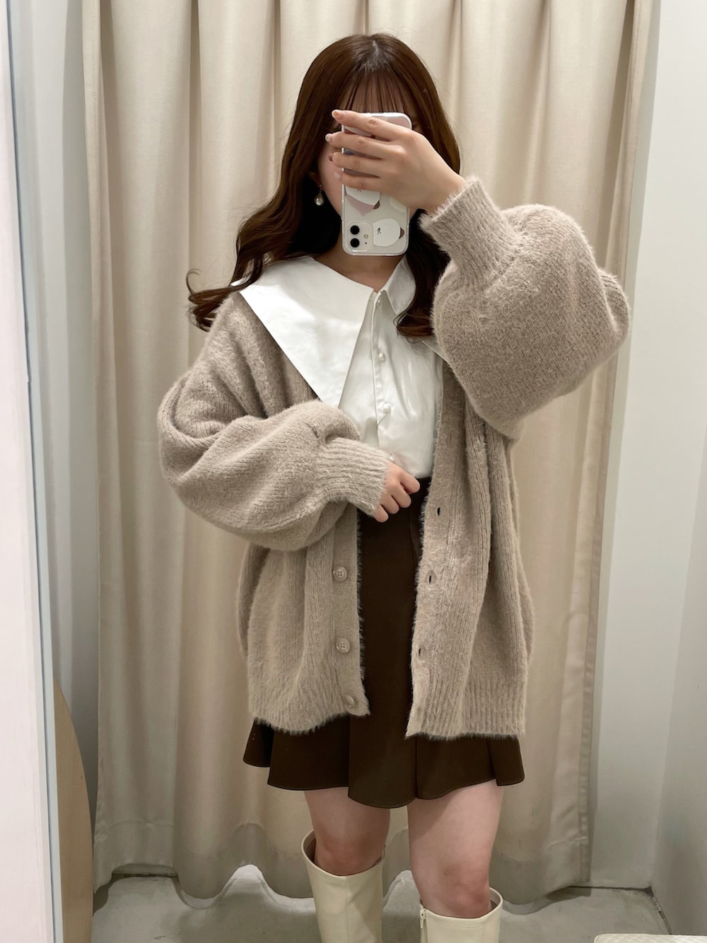 ベージュ系のカーディガン/ボレロ、ホワイト系のシャツ/ブラウス、ブラウン系のスカートを着用したレディースの秋コーディネートの2枚目の写真