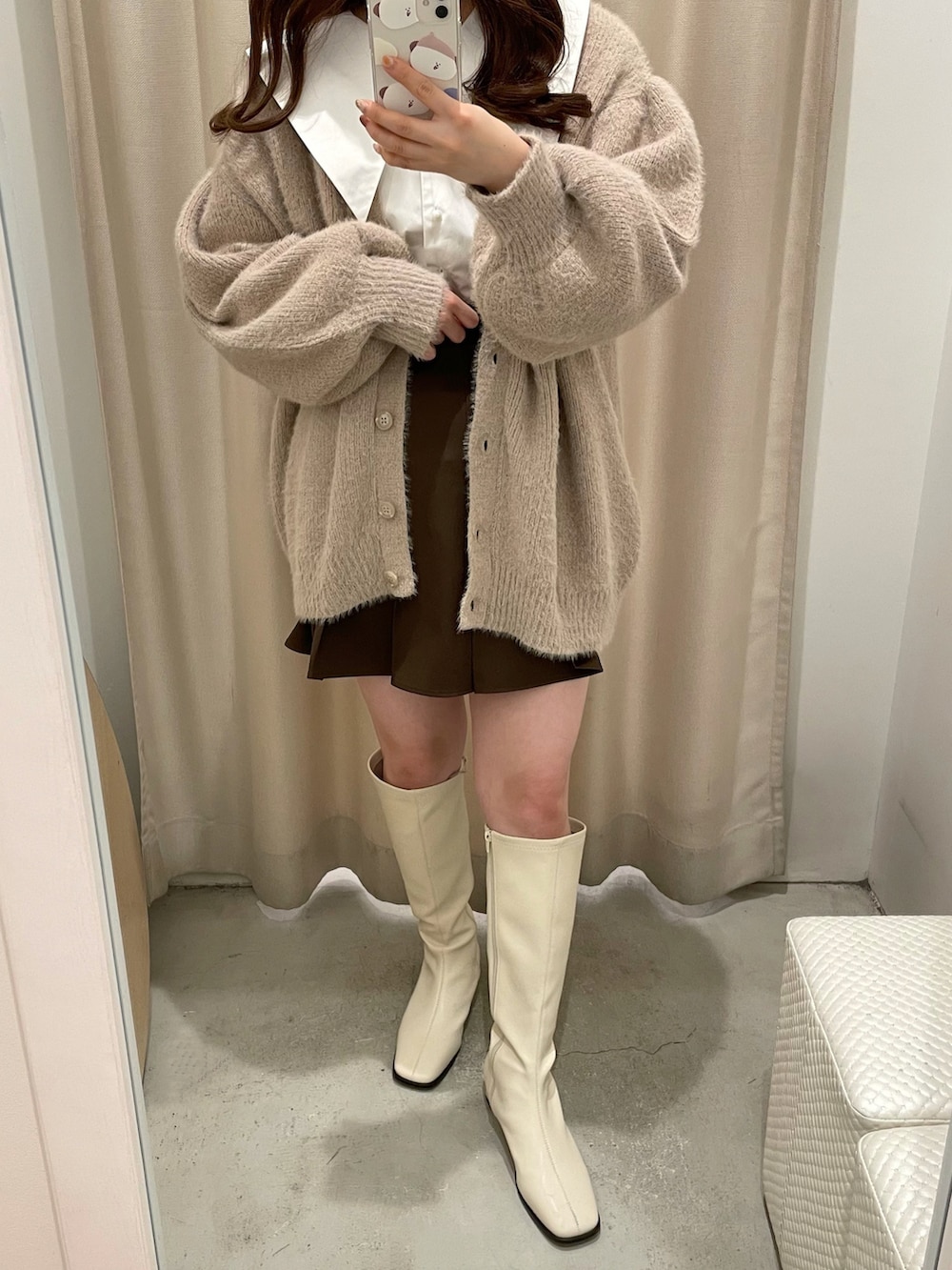 ベージュ系のカーディガン/ボレロ、ホワイト系のシャツ/ブラウス、ブラウン系のスカートを着用したレディースの秋コーディネートの3枚目の写真