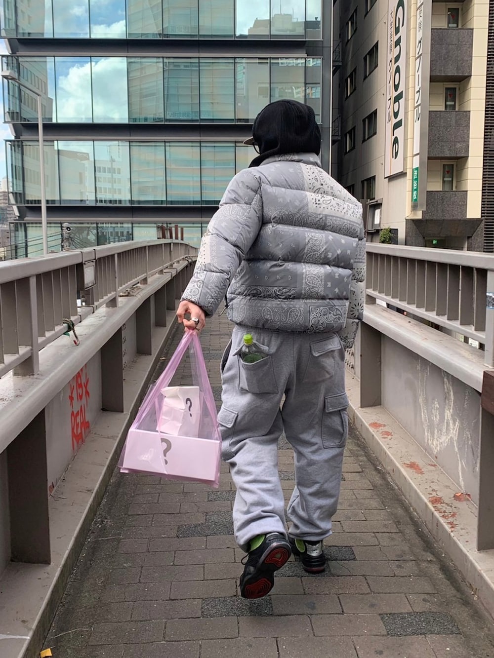 グリーン系のスニーカー、グレー系のスウェットパンツ、シルバー系のダウンジャケット/コートを着用したメンズの冬コーディネートの2枚目の写真