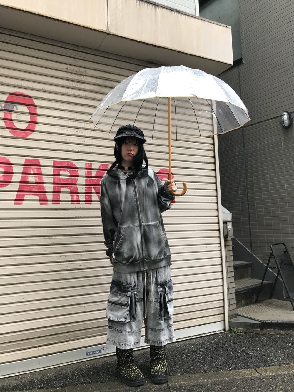 ブラック系のパーカー、グレー系のデニムパンツを着用したレディースの春コーディネートの2枚目の写真