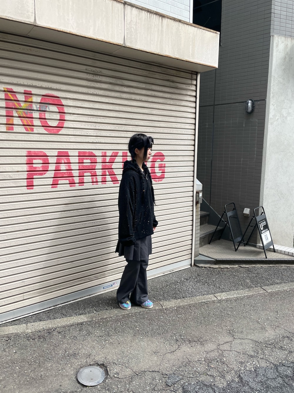 ブラック系のパーカーを着用したレディースの春コーディネートの2枚目の写真