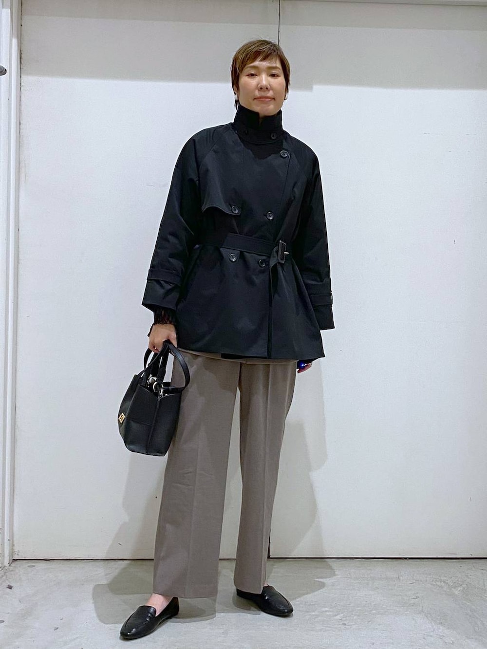 ブラック系のその他シューズ、ブラック系のTシャツ/カットソー、ブラウン系のスラックスを着用したレディースの春コーディネートの6枚目の写真