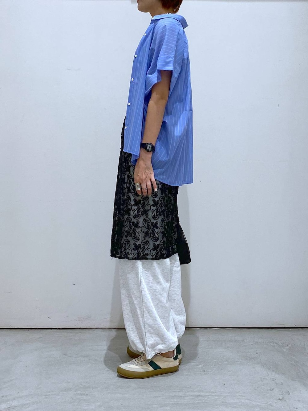 ベージュ系のスニーカー、ブラック系のショルダーバッグ、グレー系のタンクトップを着用したレディースの夏コーディネートの2枚目の写真