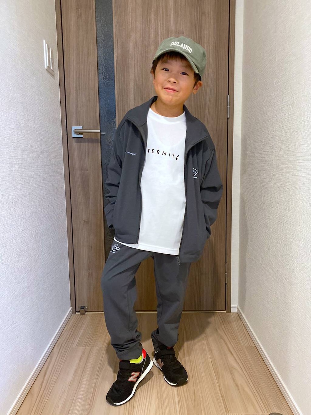 グレー系のブルゾン、ホワイト系のTシャツ/カットソー、グレー系のその他パンツを着用したキッズの秋コーディネートの2枚目の写真