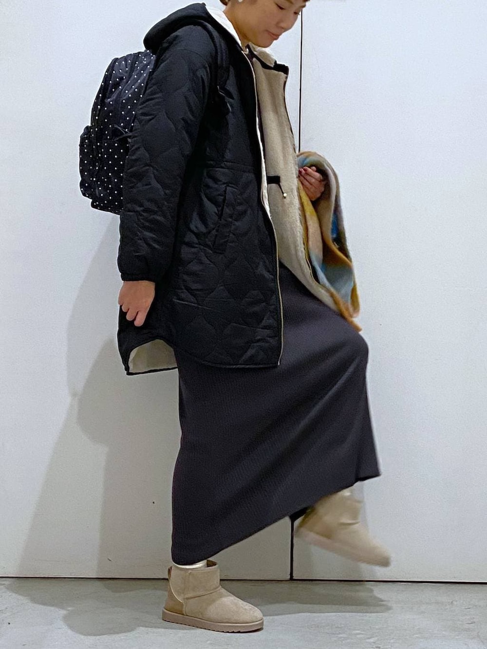 ブラック系のブルゾン、グレー系のバックパック/リュック、グレー系のワンピースを着用したレディースの冬コーディネートの4枚目の写真